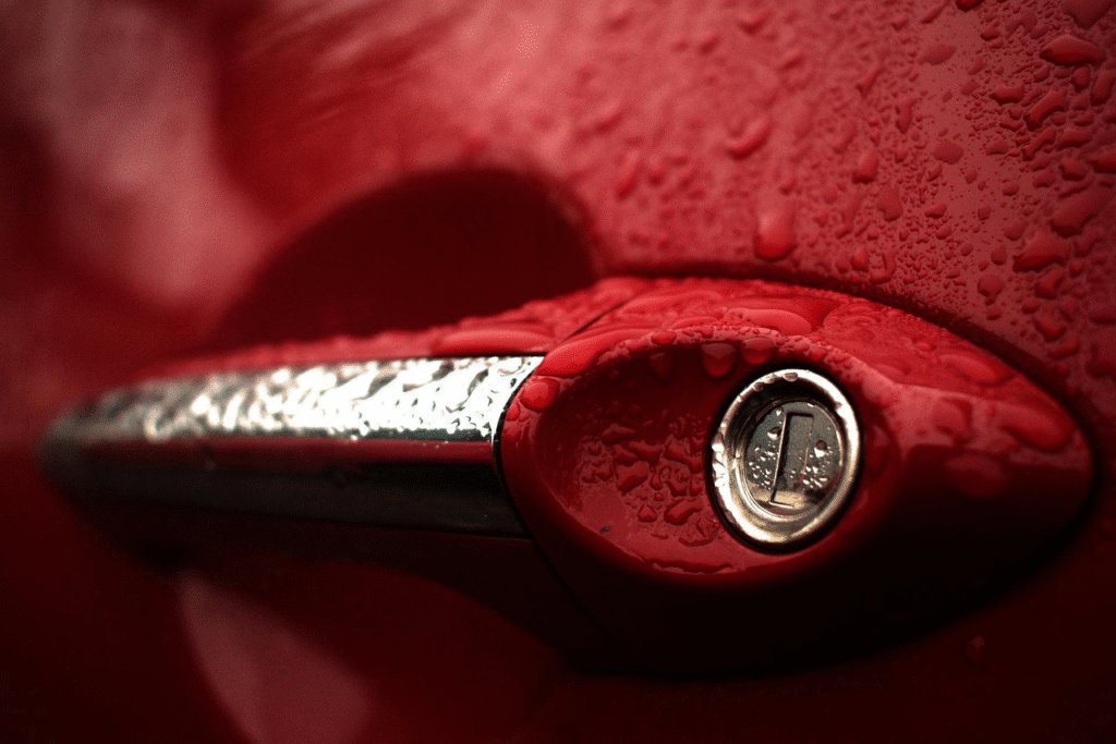 Red car door lock with water droplets